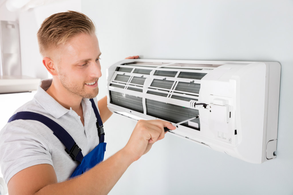 HVAC technician performing ductless air conditioning maintenance in South Jordan