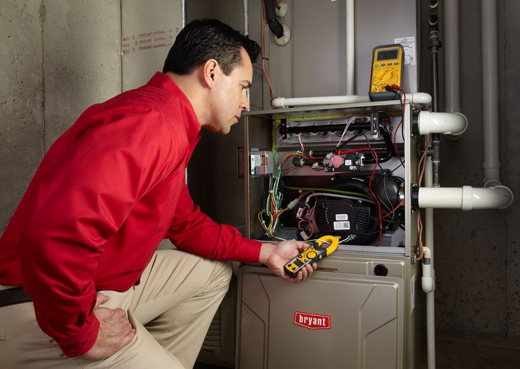 HVAC technician repairing an indoor furnace in South Jordan