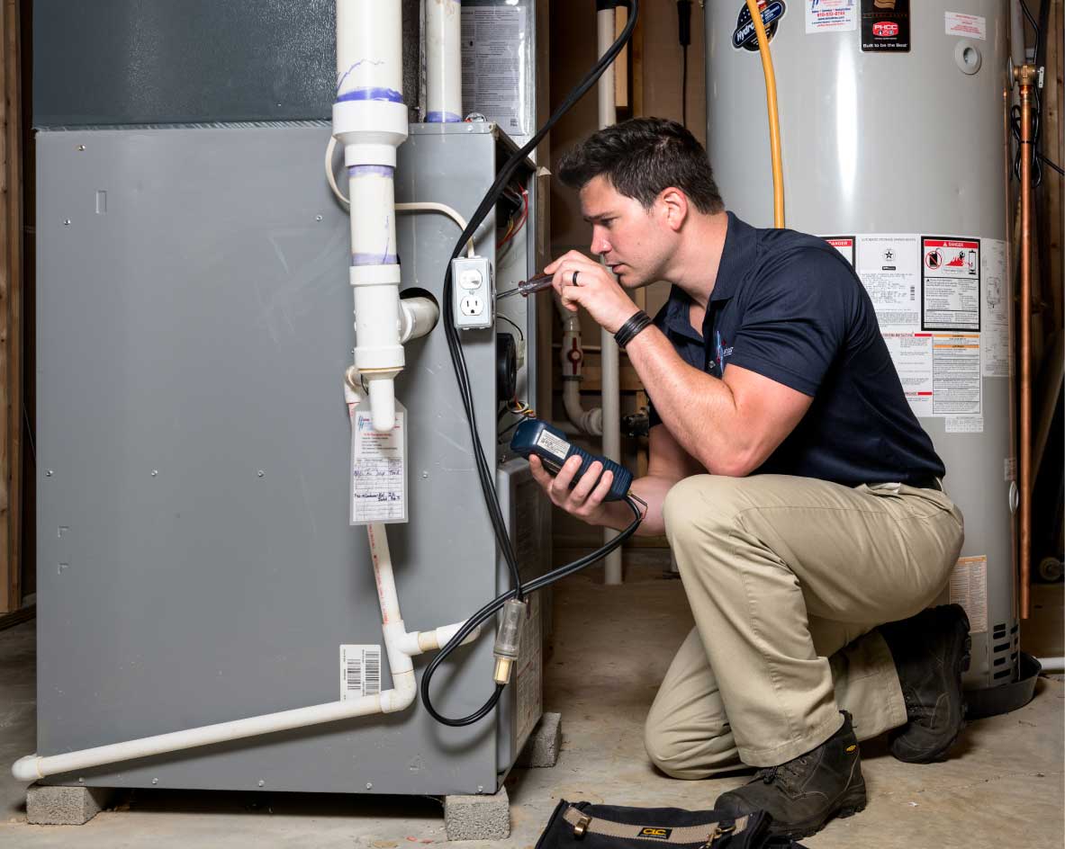 HVAC technician performing a furnace tune-up in South Jordan