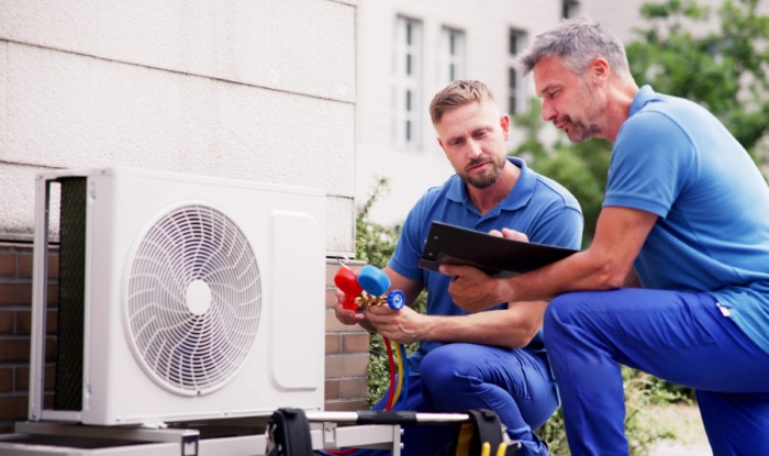HVAC technicians installing an outdoor air conditioning unit in South Jordan