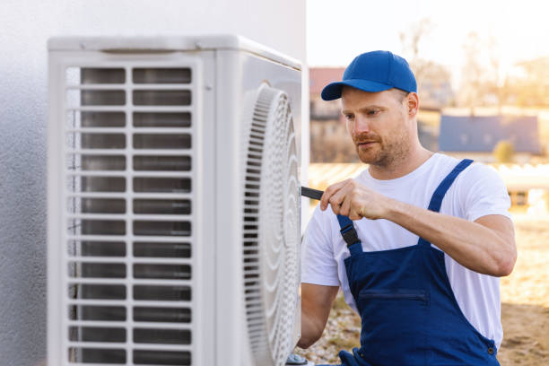 HVAC technician servicing an outdoor air conditioning unit in South Jordan