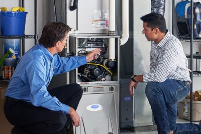 65df8c11f3e4c468cbd351a5_furnace repair vs replacement – Copy HVAC technician explaining furnace repair and maintenance to a homeowner in South Jordan, UT