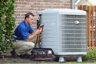 design-air-heating-and-air-conditioning-decatur-il-05 – Copy HVAC technician inspecting an outdoor air conditioning unit in South Jordan, UT